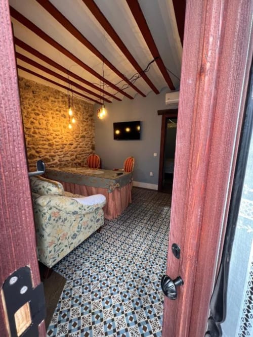 Deluxe Suite at Complejo Turístico Retiro del Teatro with exposed beams, stone walls, and modern furnishings in Almagro