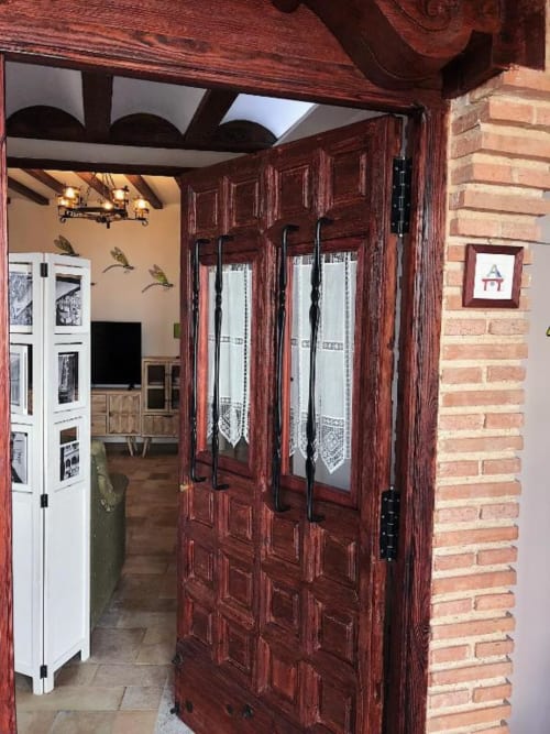 Dark wood doors with glass panels opening to Deluxe Apartment A at Retiro del Teatro, Almagro