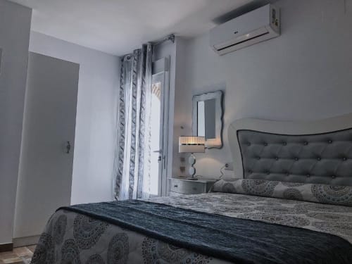 Modern bedroom in Deluxe Apartment AB at Complejo Turístico Retiro del Teatro, Almagro, with tufted headboard and air