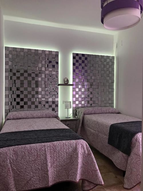 Deluxe twin bedroom with purple-tiled accent walls, ambient lighting, and modern furnishings at Complejo Turístico Retiro del