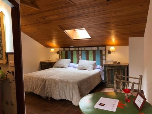 Romantic bedroom at Retiro del Teatro with wooden ceiling, queen bed, colorful headboard, and starry night views in Almagro,