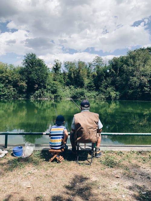 Adult and child fishing by tranquil river near La Ferme du Châtaignier gîte, Essonne