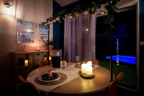 Elegant dining setup at Villa Eden Bleu in Biscarrosse with lit candles, place settings, and lit pool view at night