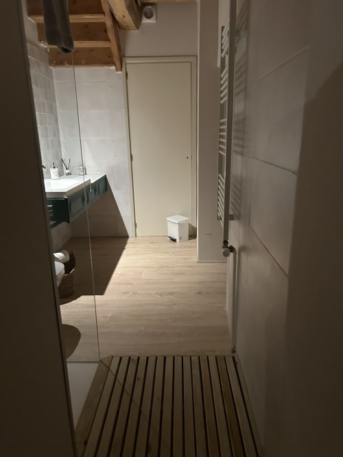 Baño moderno en la habitación MUSSOL de Casa Tapiolas BnB, Molló Girona con ducha abierta y suelo de madera