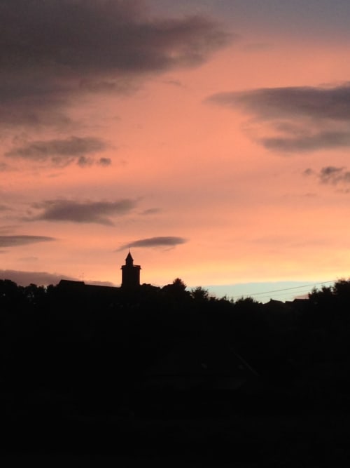 Church steeple silhouetted at sunset over Pourrain, Domaine de l'Ocrerie