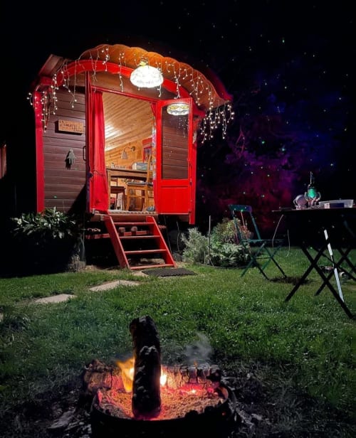 Red caravan cottage at night with campfire, garden view at Les Refuges Du Chalet, Jalhay Belgium