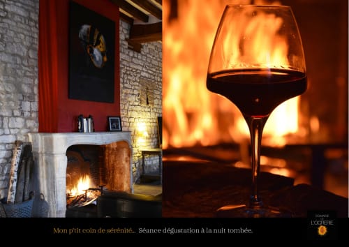 Verre de Bourgogne rouge près de la cheminée au Domaine de l'Ocrerie, Pourrain. Ambiance chaleureuse avec les flammes.