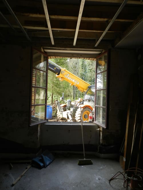 View through open doors of yellow construction equipment at Domaine de l'Ocrerie in Pourrain, France