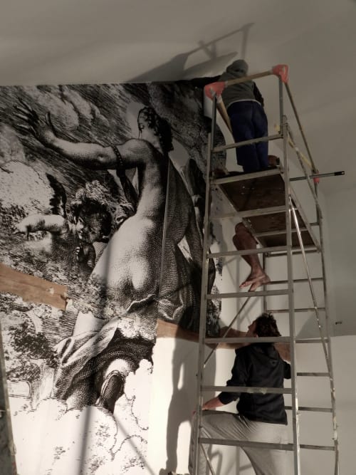 Workers installing large-scale engraving mural at Domaine de l'Ocrerie boutique hotel in Pourrain, France