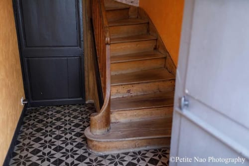 Escalier ancien et les carreaux de ciment de l'entrée des appartements de la maison Au Jardin des deux ponts