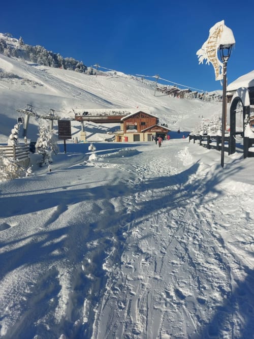 Base enneigée de la station de ski CMD Méribel Le Pralin avec chalet en bois, remontée mécanique et pistes immaculées, Les Allues