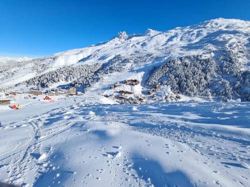 Paysage alpin enneigé au CMD Méribel Le Pralin aux Allues avec pistes de ski et montagnes boisées