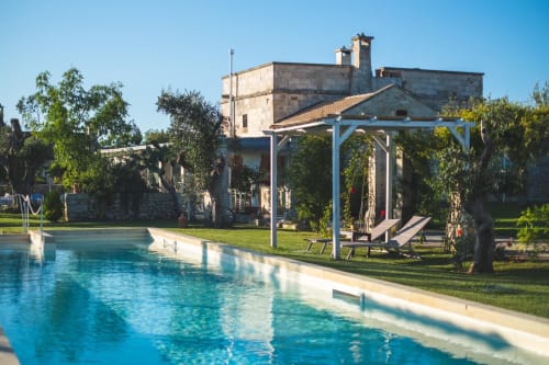 Piscine de la Masseria Vittoria avec bâtiment en pierre et pergola à Acaya, Italie