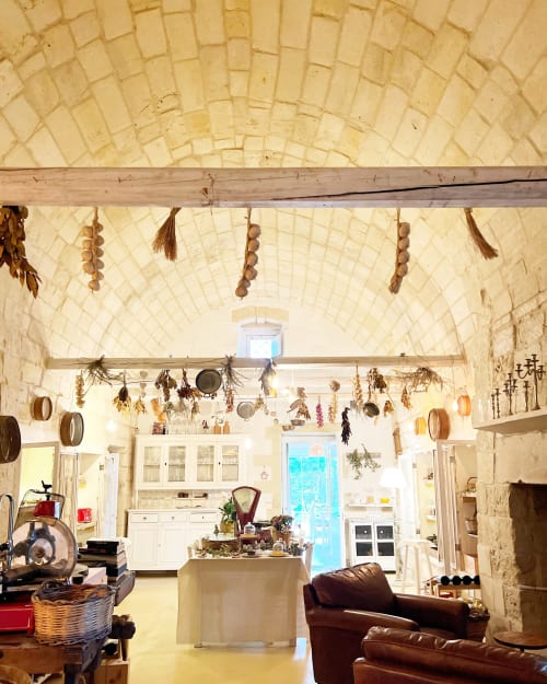 La cucina rustica di Masseria Vittoria con volta a botte, erbe aromatiche appese e il fascino tradizionale della campagna italiana