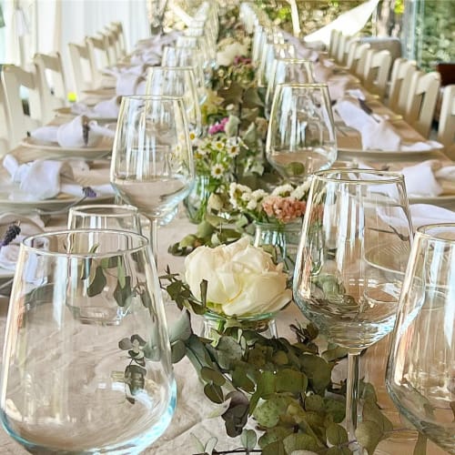 Elegant outdoor dining setup at Masseria Vittoria with wine glasses, white flowers, and place settings in Acaya, Italy