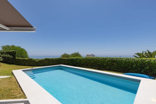 Piscina junto a los apartamentos, con vistas al mar.