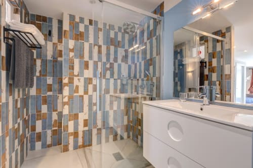 Salle de bain avec grande douche italienne et lavabo avec miroir bien éclairé 