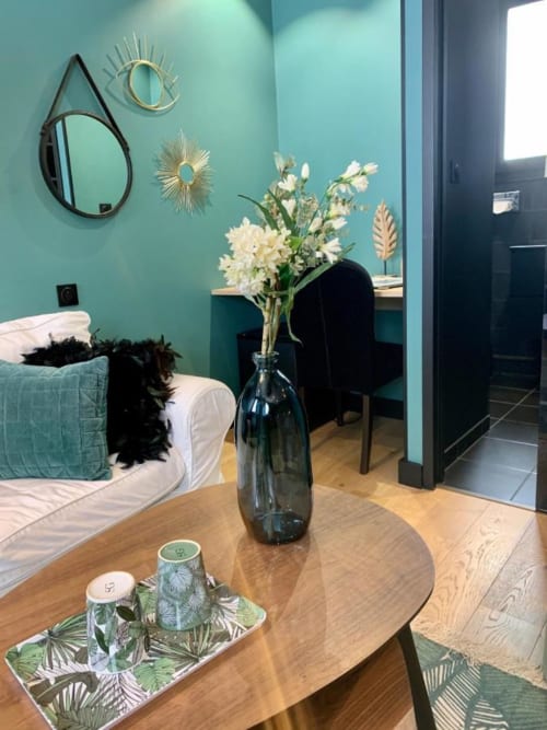 Chambre d'hôtel moderne au Be Hotel Le Touquet avec murs turquoise, bureau en bois, composition florale et décoration contemporaine