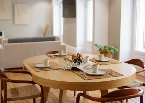 Elegant gedekte eettafel in appartement Maison Lùisa in Autun met houten stoelen en verse bloemen