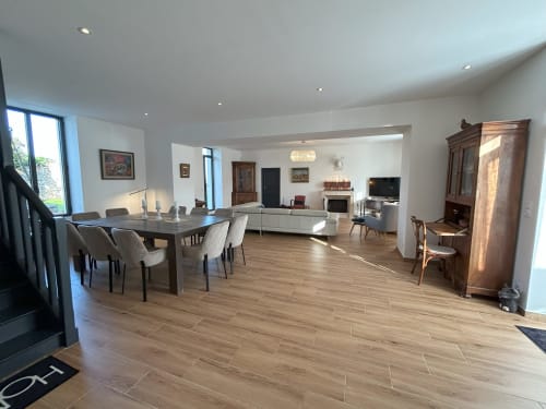 Spacieux salon ouvert à La Ferme du Châtaignier avec table à manger, mobilier moderne et cheminée