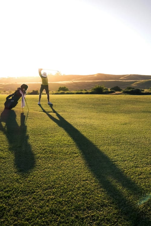 Golfeurs au coucher de soleil sur un parcours verdoyant avec collines ondulantes près de Masseria Vittoria, Acaya