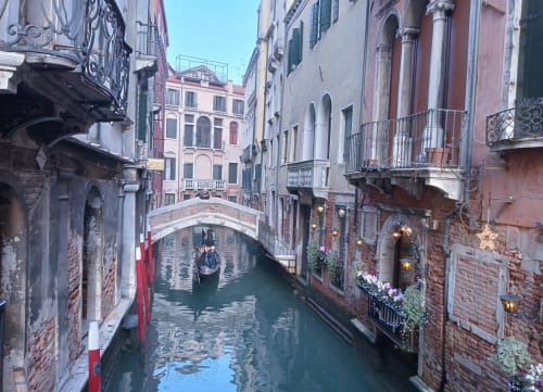 Suggestivo canale veneziano con gondola, ponte arcato e storici edifici a Treviso, Italia