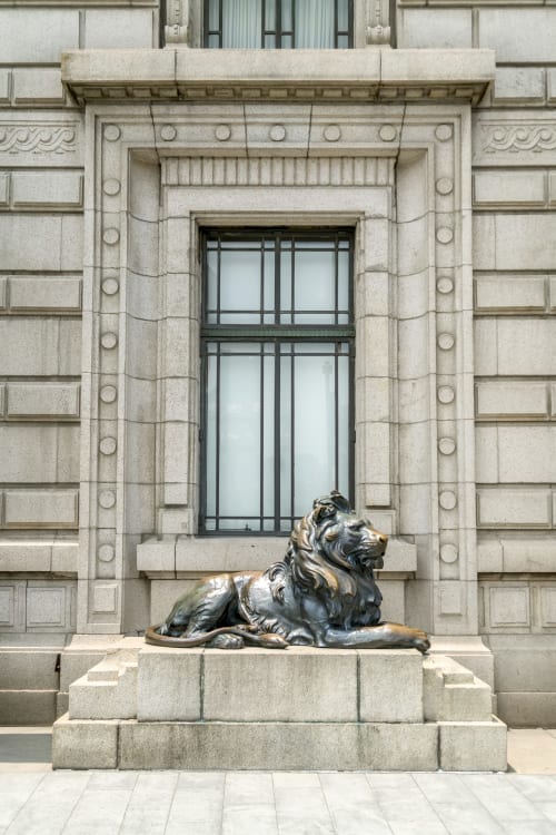 Estatua de león de bronce bajo ventana ornamentada en el hotel Alojamientos Río Cares de León, España