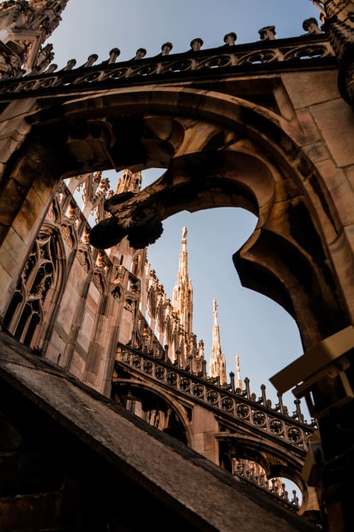 Arquitectura gótica con gárgola y agujas enmarcadas por arco de piedra ornamental en León, España