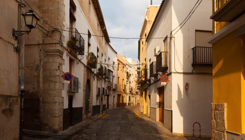 Pintoresca calle empedrada en León con coloridas casas históricas y balcones de hierro forjado cerca de Alojamientos Río