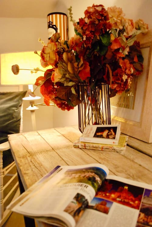 Arrangement floral automnale et magazines de voyage sur bureau en bois à La vie de château B&B, Grignan France