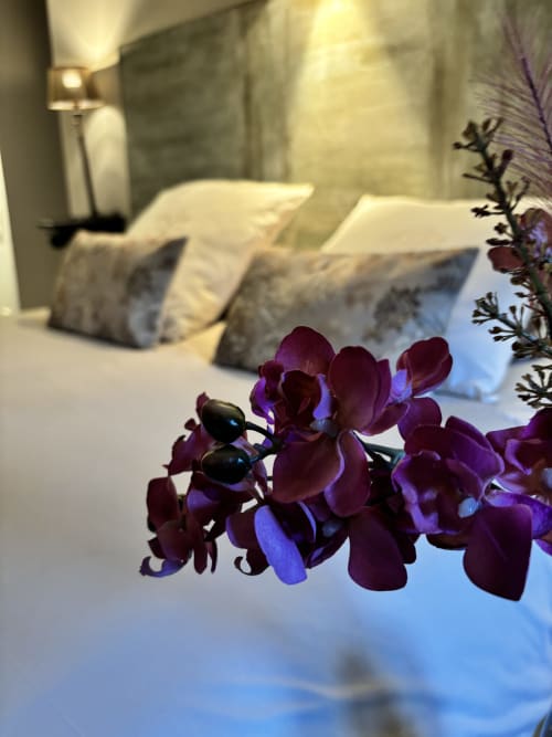 Orchidées pourpre foncé sur le lit à La vie de château, hôtel-boutique à Grignan, France
