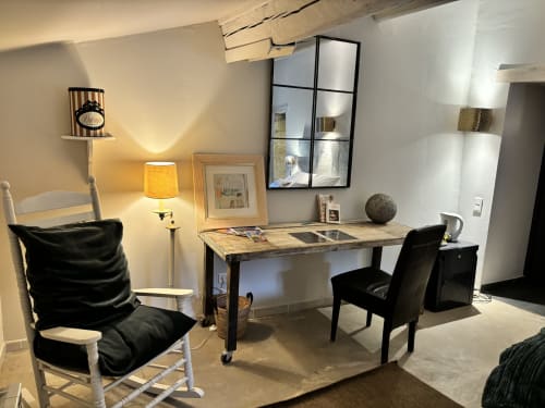 Espace de travail moderne à La vie de château B&B à Grignan avec bureau, chaises noires et éclairage chaleureux
