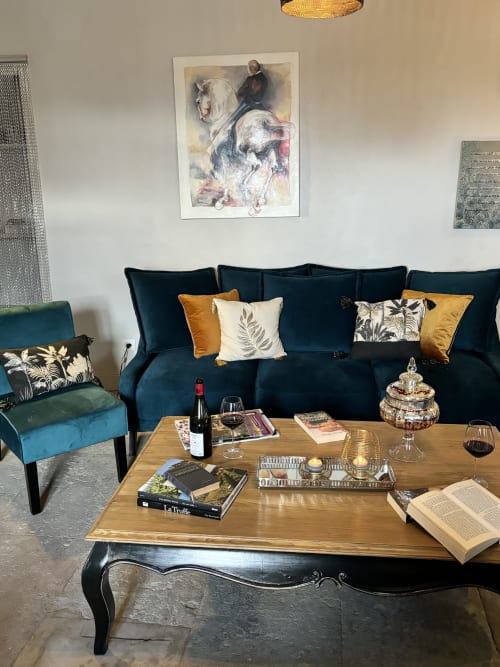 Élégant salon de La vie de château à Grignan avec canapé bleu marine, touches dorées et œuvres d'art
