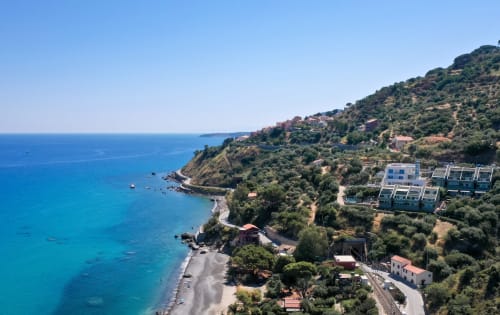 CefalHome coastal cliffside property overlooking turquoise Mediterranean Sea with terraced gardens and modern accommodations