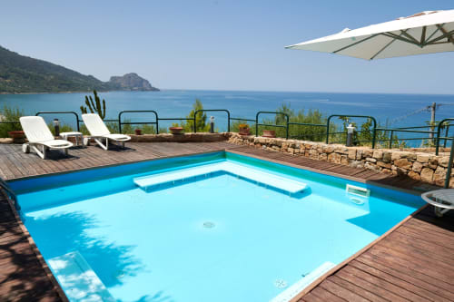 CefalHome pool terrace with azure water, loungers, and Mediterranean sea view from Rome property