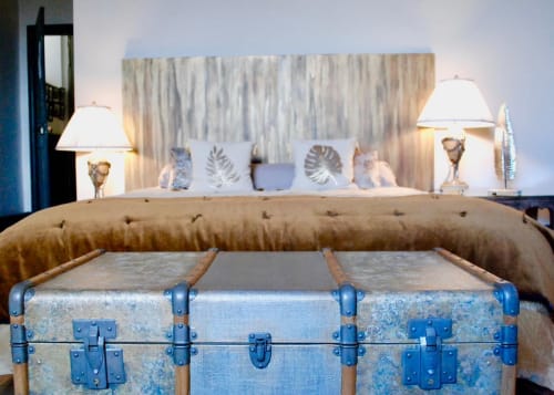 Ancienne valise au pied du lit avec tête de lit en oreillers à La vie de château B&B à Grignan, France