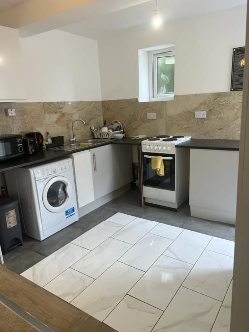 Garden Flat kitchen at Starlet Property London with washing machine, oven, and tile flooring