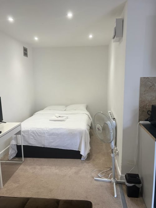 Bedroom in Starlet Property Garden Flat, London with bed, desk, fan, and recessed ceiling lights