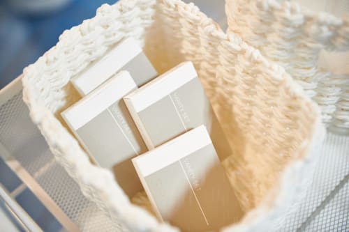 Luxury skincare products displayed on cream-colored towels at CefalHome Rome hotel
