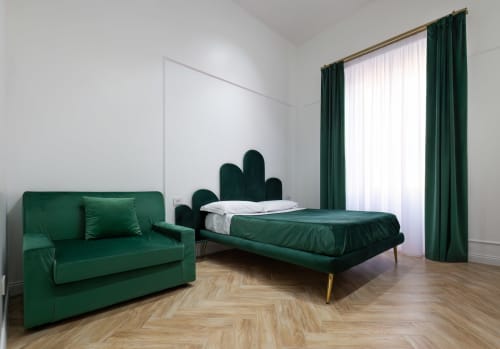 Camera Superior moderna al Garibaldi 125 di Napoli con letto in velluto verde, divano, pavimenti in legno e tende con vista sulla città