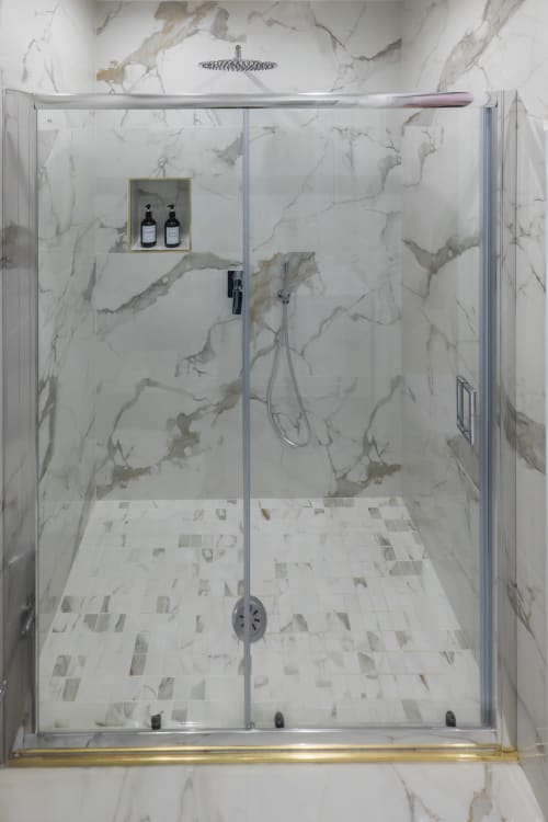 Luxurious marble shower enclosure at Garibaldi 125 Naples with rainfall showerhead and amenities shelf