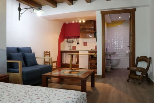 Estudio Apartamentos Casa Lafuente con asientos azules, cocina americana, baño y vigas de madera en Lukiano, Araba