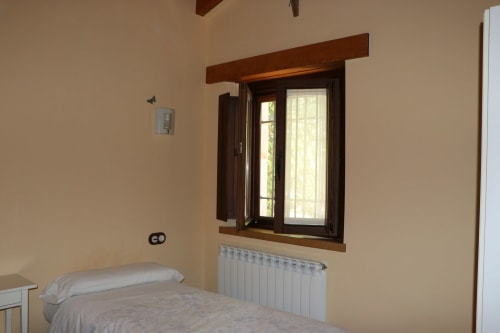 Dormitorio luminoso en Casa Lafuente en Lukiano con vista a las montañas, radiador y cama confortable