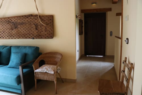 Sala de estar del apartamento Casa Lafuente con sofá turquesa, silla de mimbre y acceso a la entrada en Lukiano, Araba