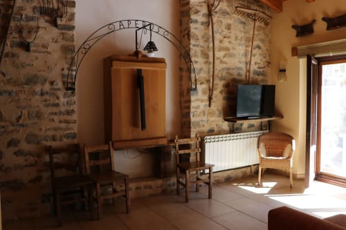 Sala de estar rústica en Casa Lafuente con paredes de piedra, muebles de madera, chimenea, televisor y zona de estar