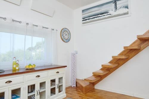 Cucina moderna e luminosa con scala in legno, arredamento bianco e arredo costiero presso CefalHome Rome