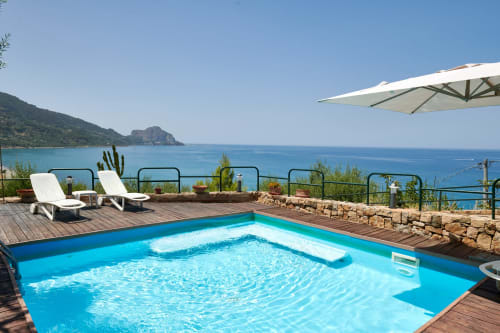 CefalHome luxury pool with sunbeds overlooking turquoise Mediterranean Sea and coastal cliffs