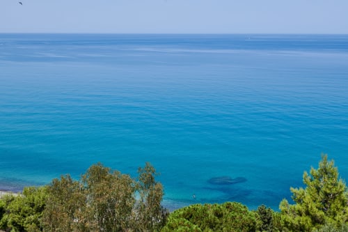 Turquoise Mediterranean sea with lush green vegetation overlooking coastal waters near Rome