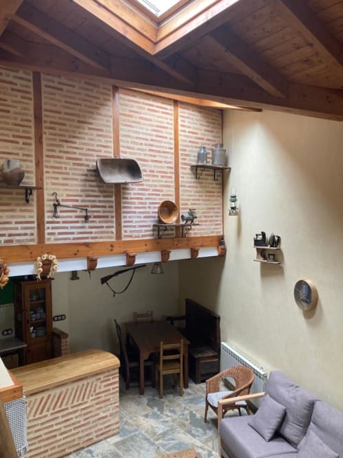 Interior rústico de Casa Lafuente con ladrillos expuestos, vigas de madera, sala de estar y vistas a la montaña