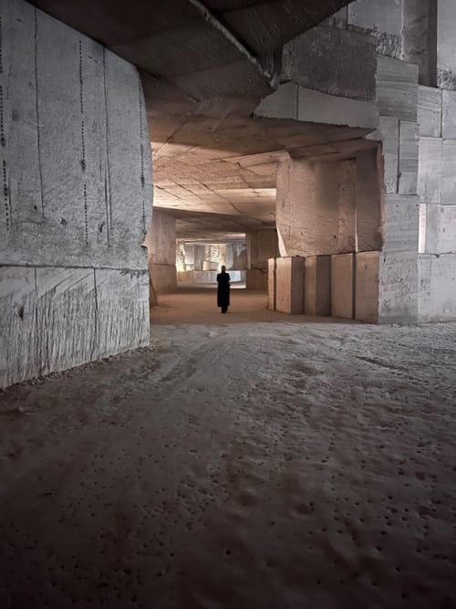 Rustic corridor at Domaine de l'Ocrerie in Pourrain with exposed stone walls and sandy floor